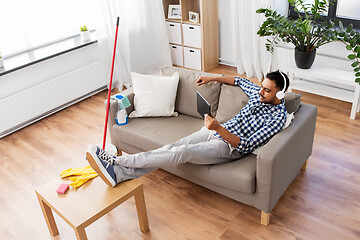 Image showing indian man in headphones after cleaning home