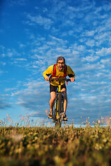 Image showing Cyclist man standing on top of a mountain with bicycle