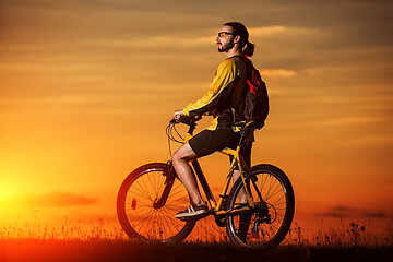 Image showing silhouette of the cyclist riding a road bike at sunset