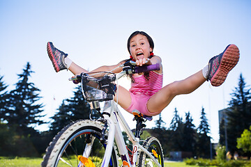 Image showing Portrait of funny girl in pink clothes on her bike