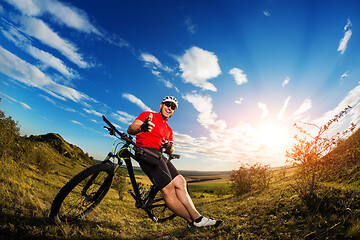 Image showing Low angle view of man riding bicycle against sky