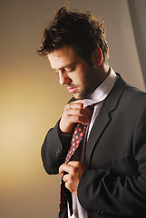 Image showing A knotting a tie