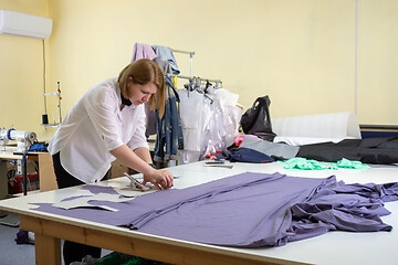 Image showing Fashion designer cuts on the material details of clothes in the 