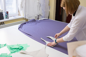 Image showing cutting the fabric on a large table in a sewing workshop