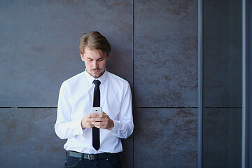 Image showing startup businessman in a white shirt with a tie using mobile pho