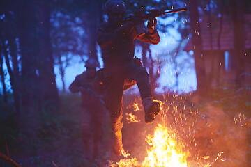 Image showing Soldier in Action at Night jumping over fire