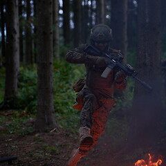 Image showing Soldier in Action at Night jumping over fire