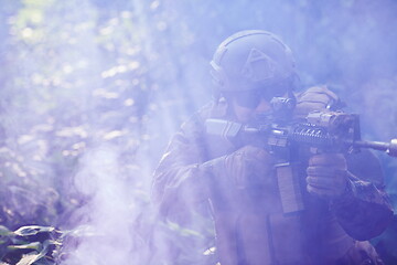 Image showing soldier in action aiming  on laser sight optics