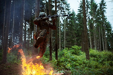 Image showing Soldier in Action at Night jumping over fire