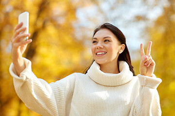 Image showing woman taking selfie by smartphone at autumn park