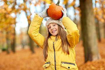 Image showing happy girl with pumpkin at autumn park