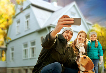 Image showing family with dog taking selfie over house in autumn