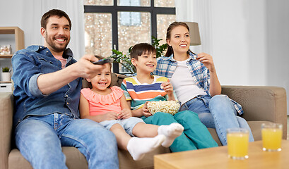 Image showing happy family with popcorn watching tv at home