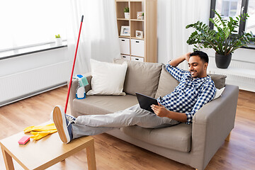 Image showing man with tablet computer after home cleaning