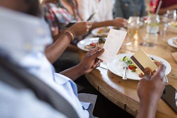 Image showing hands holding bill and credit card at restaurant