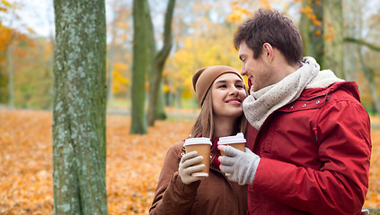 Image showing happy couple with coffee walking in autumn park