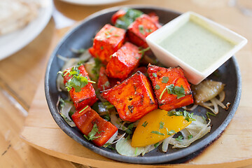 Image showing close up of paneer tikka dish with sauce on table