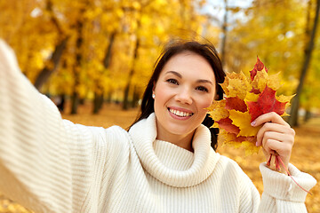 Image showing woman with leaves taking selfie in autumn park