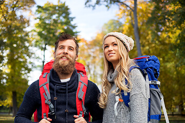 Image showing smiling couple with backpacks hiking in autumn