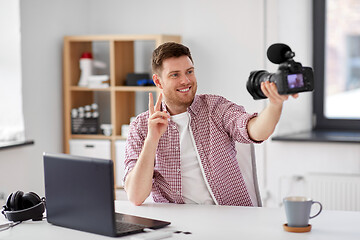 Image showing male video blogger with camera blogging at home