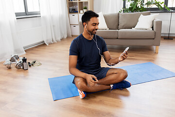 Image showing indian man with smartphone on exercise mat at home