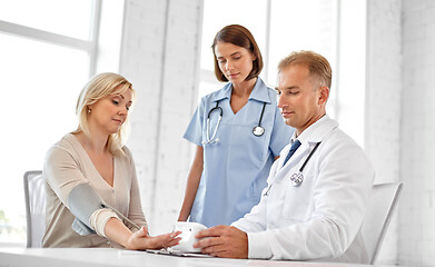 Image showing doctor measuring patient woman\'s blood pressure