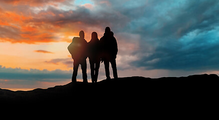 Image showing group of travellers with backpacks over sunset