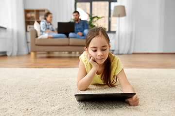 Image showing girl with tablet computer lying on floor at home