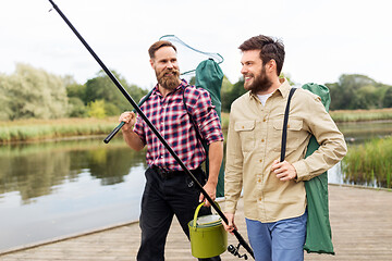 Image showing male friends with net and fishing rods on lake