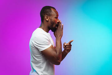 Image showing African-american young man\'s portrait on gradient studio background in neon