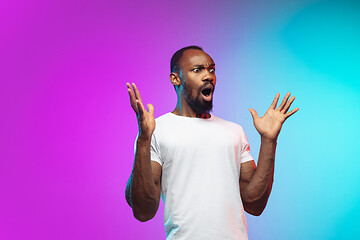 Image showing African-american young man\'s portrait on gradient studio background in neon