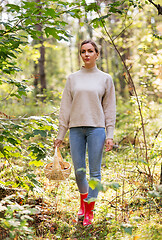 Image showing woman with basket picking mushrooms in forest