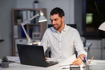 Image showing businessman with laptop working at night office