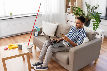 Image showing man with laptop shopping online after cleaning