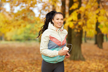 Image showing woman running in park and listening to music