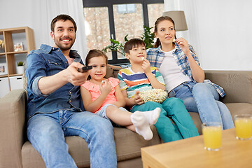 Image showing happy family with popcorn watching tv at home