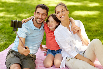 Image showing family having picnic and taking selfie at park