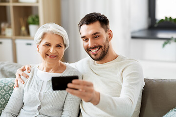 Image showing senior mother with adult son taking selfie at home