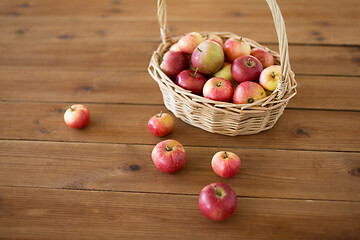 Image showing ripe apples in wicker basket on wooden table