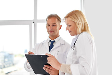 Image showing smiling doctors with clipboard at hospital