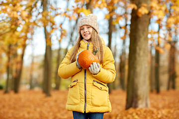 Image showing happy girl with pumpkin at autumn park