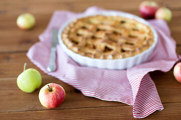 Image showing close up of apple pie in baking mold and knife