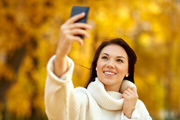 Image showing woman taking selfie by smartphone at autumn park