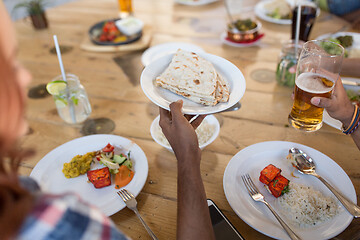 Image showing international friends eating at restaurant