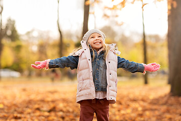 Image showing happy little girl with open arms at autumn park