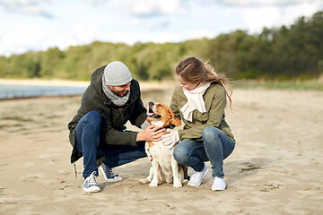 Image showing happy couple with beagle dog on autumn beach