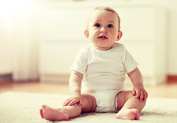 Image showing happy baby boy or girl sitting on floor at home