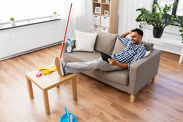 Image showing man with tablet computer after home cleaning