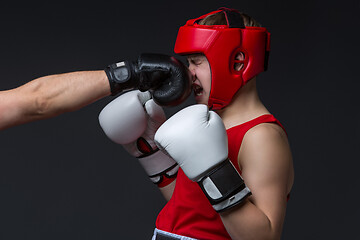 Image showing young boxer is being punched