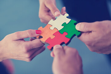 Image showing Group of business people assembling jigsaw puzzle